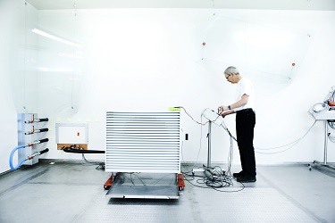 Billedet viser en person, som er ved at teste en varmepumpe i det nye varmepumpelaboratorium.