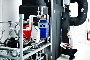 Billedet viser en mander som arbejder i teknikrummet til varmepumpelaboratoriet.