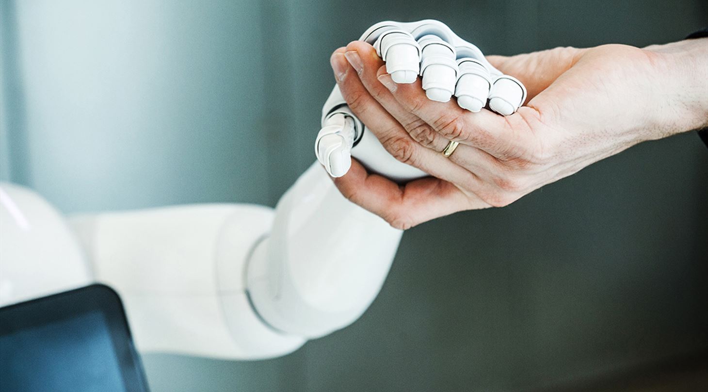 A robot hand holding a human hand
