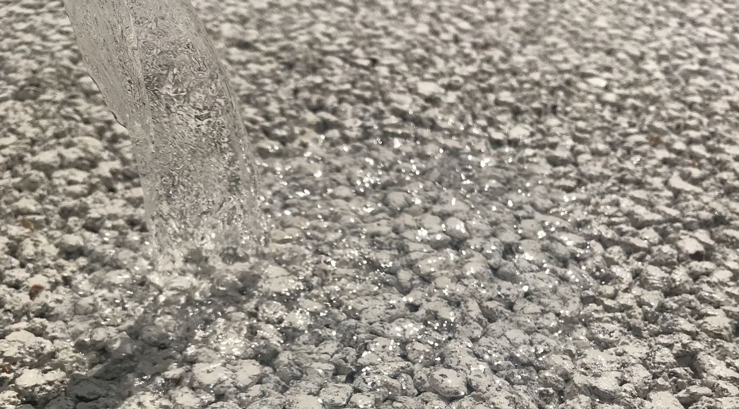 Billedet viser vand der hældes igennem permeabel beton.