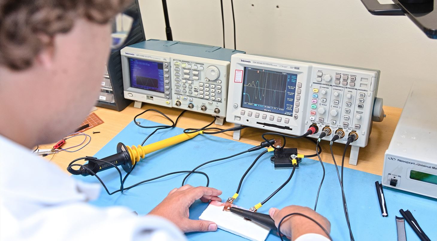 Employee is performing electrical measurement tests and a response is seen on the output screen