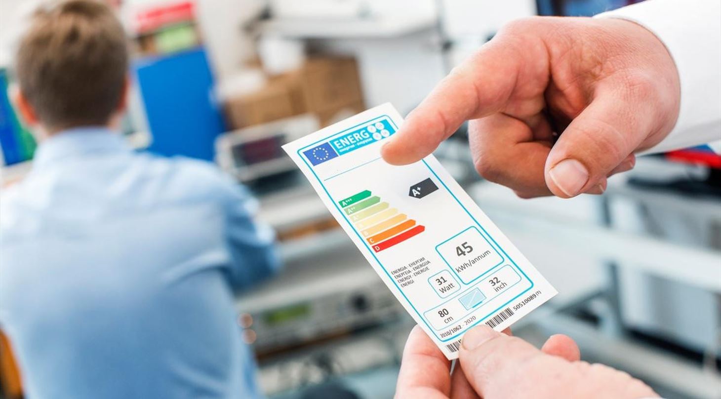 A male hand holding a eco-labeling showing energy consumption and energy efficiency