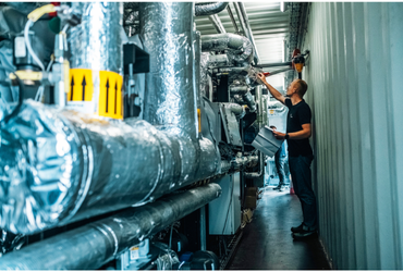 Billede fra containere med HTHPs i drift og medarbejdere der arbejder