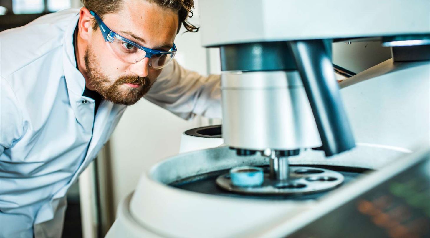 Mand studerer metalemne i lab