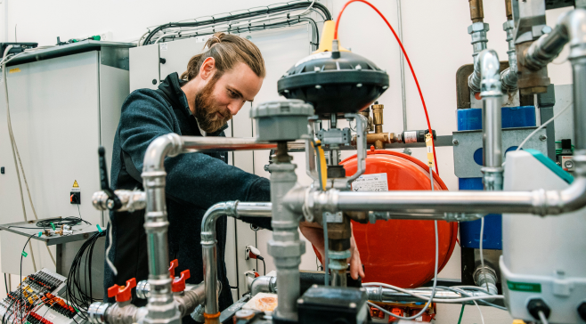 A test engineer working on a test rig in the Heat Pump Test Laboratory at Danisk technological Institute.