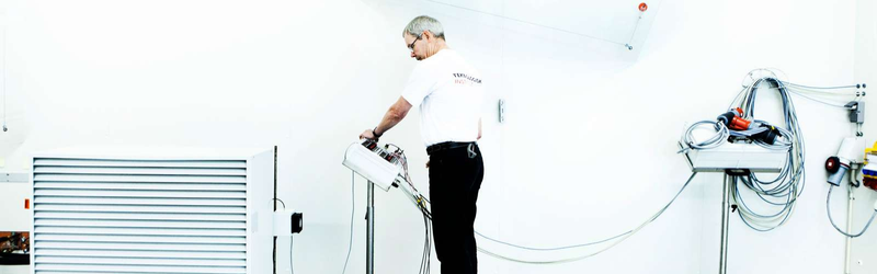 The picture shows a test engineer carrying out a test in the Heat Pump Test Laboratory at Danish Technological Institute