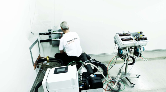 The picture shows a test engineer preparing for testing in the Heat Pump Test Laboratory at Danish Technological Institute