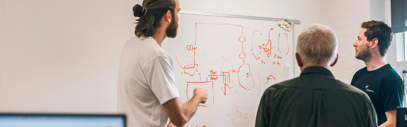 The picture shows three test engineers in front of a white board in the Heat Pump Test Laboratory at Danish Technological Institute
The picture shows three test engineers in front of a white board in the Heat Pump Test Laboratory at Danish Technological